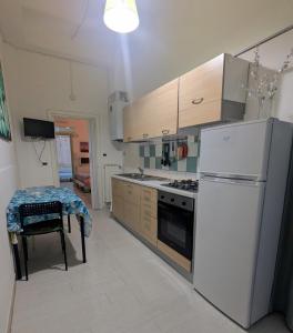 a kitchen with a refrigerator and a table with a chair at Nei pressi del mare in Termoli +13 photos