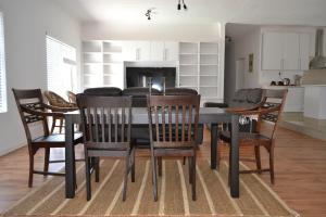 a dining room with a black table and chairs at 4 Kiaat Suites in Klerksdorp