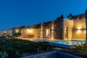 a villa with a swimming pool at night at Mardanza Exclusive in Imerovigli