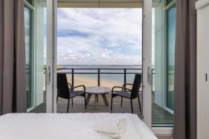 a bedroom with a bed and a view of the beach at Vakantiewoning aan het water - met 2 balkons - Vista Maris - Nr 38 in Sint Annaland