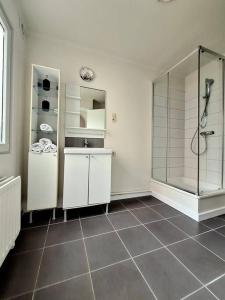 a bathroom with a shower and a tiled floor at La Suite Alice in Brussels