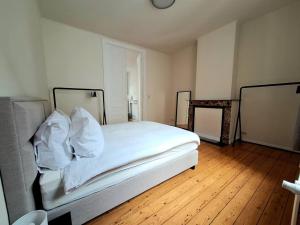 a bedroom with a bed with white sheets and pillows at La Suite Alice in Brussels +4 photos