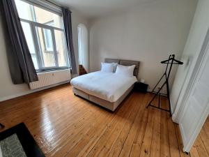 a bedroom with a bed and a large window at La Suite Alice in Brussels