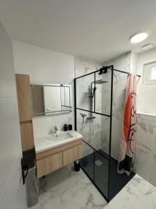 a bathroom with a sink and a glass shower at Villa ISKA - 6Velos-Calme-Piscine-Moderne-Centre-Port-Plages in La Tremblade