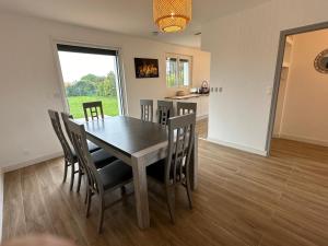 a kitchen and dining room with a table and chairs at Villa ISKA - 6Velos-Calme-Piscine-Moderne-Centre-Port-Plages in La Tremblade