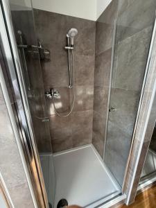 a shower with a glass door in a bathroom at ENSAS rooms in Koblenz +28 photos