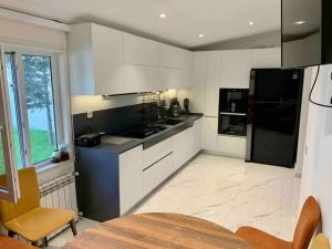 a kitchen with black and white appliances and a table at Exclusive Luxury Villa With Pool & Sauna near Sea Breeze in Baku