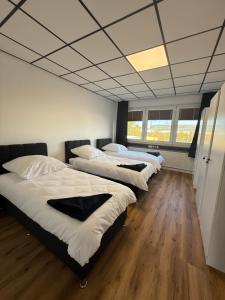 a row of beds in a room with wooden floors at ENSAS rooms in Koblenz