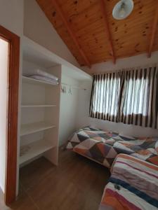 a bedroom with two beds and a wooden ceiling at Los Colibríes in Lago Puelo