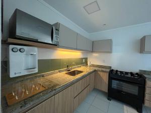 a kitchen with a sink and a microwave at 402 Avelã - 2Q com VistaMar Incrível in Cabo Frio
