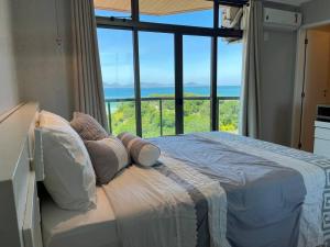 a bedroom with a bed with a view of the ocean at 402 Avelã - 2Q com VistaMar Incrível in Cabo Frio +34 photos