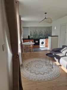 a living room and kitchen with a couch and a table at Chez Julie et Julien in Saint-Jean-de-Maurienne