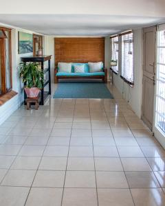 a living room with a couch on a tiled floor at The Salty Surf Shack in Cape Town