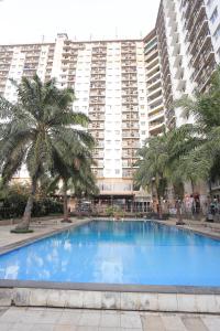 a large swimming pool in front of a large building at Apartemen Mutiara Bekasi by Alfa Rooms in Pekayon Satu