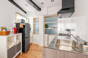 a kitchen with a stainless steel sink and a refrigerator at Sakura House in Nagano