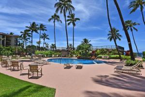Un resort con piscina, sillas y palmeras. en Hale Ono Loa 401, en Kahana