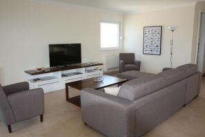 a living room with a couch and a tv at Pinna Nobilis Apartments - Ground Floor in Brodarica