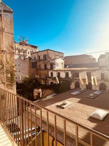 a balcony with a wooden table and buildings at Casa nonno Enrico in via Oreto in Palermo