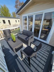 a patio with a couch and chairs on a house at The Shutt's Escapes - Tattershall Lakes in Tattershall