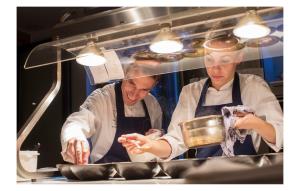 two chefs standing in a kitchen preparing food at Hotel Restaurant Vous lé Vous in Hasselt