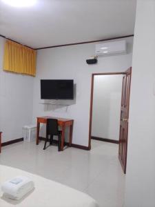 a room with a desk and a television and a table at Apartamento 300 Tercer piso,cómodo ,amplio,privado in Iquitos
