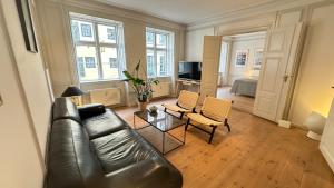a living room with a leather couch and a table at The Admirals Apartments 1 & 2 in Copenhagen +30 photos
