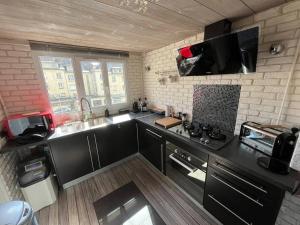 a kitchen with a sink and a stove top oven at Le petit Refuge - hyper centre Compiegne in Compiègne