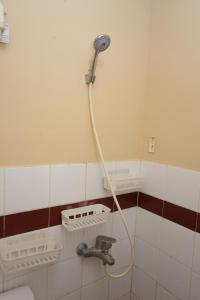 a shower in a bathroom with a hose on the wall at Apartemen Mutiara Bekasi by Alfa Rooms in Pekayon Satu