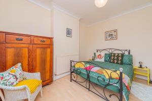 a bedroom with a bed and a chair and a dresser at Monet's in Telford +9 photos