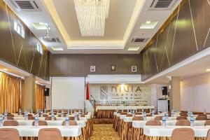 une salle de conférence avec des tables et des chaises ainsi qu'un podium dans l'établissement NIVIA HOTEL, à Pulauberayan Dadap