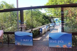 a deck with glass doors with signs that say sesame pigs at Destino Floripa Jurerê Beach Village in Florianópolis