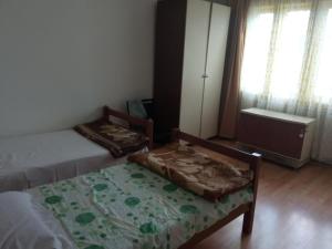 a bedroom with two beds and a window at City Rooms 400m from Center in Mitrovica +22 photos