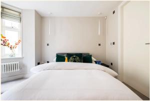 ein Schlafzimmer mit einem weißen Bett und einem Fenster in der Unterkunft Home Sweet Hampstead Heath in London