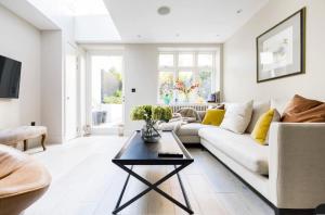 ein Wohnzimmer mit einer weißen Couch und einem Tisch in der Unterkunft Home Sweet Hampstead Heath in London