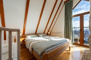 Un dormitorio con una cama y una ventana grande. en Vila Sun forest, en Žabljak