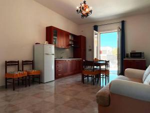 a kitchen with a refrigerator and a table with chairs at West Sicily - Villa with Garden and Parking in Marsala