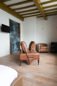 a room with two chairs and a painting on the wall at Hotel De Heeren in Veere