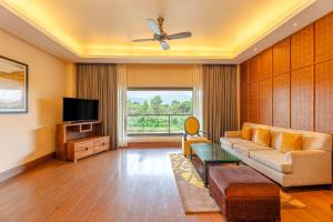 卡尔贾特Radisson Blu Plaza Resort & Convention Centre Karjat的带沙发和电视的客厅