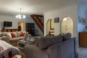 a living room with a couch and a table at Langebaan 4 Bedroom Holiday Home in Langebaan
