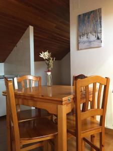 タウイにあるApartament Casa Xulla 2の木製のダイニングテーブル(椅子付)、花瓶