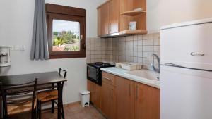 a kitchen with a sink and a white refrigerator at Katerina-Maria Studios & Apartments in Vourvourou