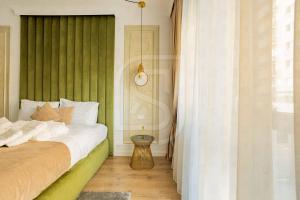 a bedroom with a bed with a green wall at Atlas by Kristal Collection in Bucharest +64 photos