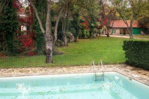 a swimming pool in a yard with a fence at Finca La Machota Centro de Naturaleza in Peralejo