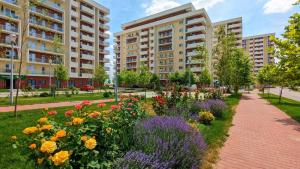 a garden of flowers in a park with buildings at Atlas by Kristal Collection in Bucharest