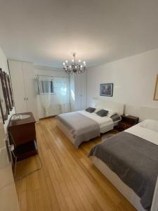 a bedroom with two beds and a chandelier at Apartmani SEA VIEW in Lokva Rogoznica