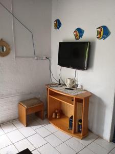 a tv sitting on top of a wooden stand with a monitor at Cantinho da paz in São Roque