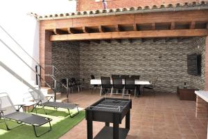 a patio with chairs and tables and a brick wall at Can Teixidó in Arbeca