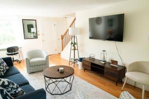 a living room with a blue couch and a tv at Charming & Cozy 3BR home mins to SU-ESF-Upstate-Le Moyne in Syracuse