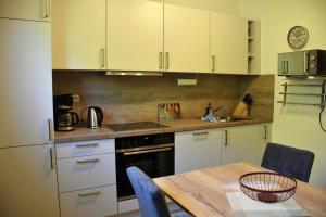 a kitchen with white cabinets and a wooden table with a tableablish at Strandkiesel in Büsum