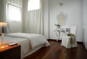 a white bedroom with a bed and a table at Villa Moro Lin Design Apartments in Mestre